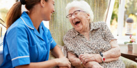 Senior,Woman,Sitting,In,Chair,And,Talking,With,Nurse,In